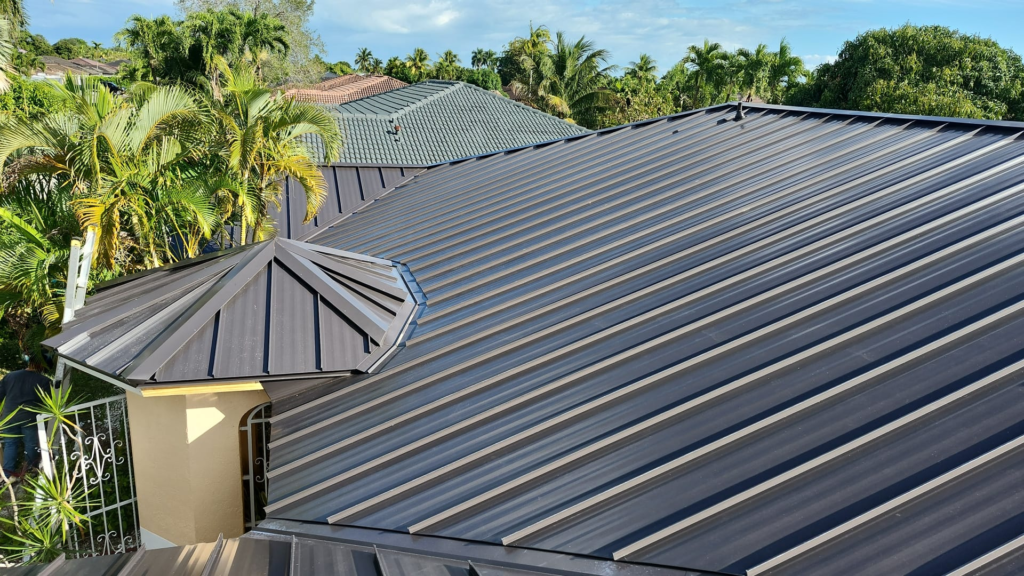 Roofing contractors installing metal roofing panels on a house in Florida