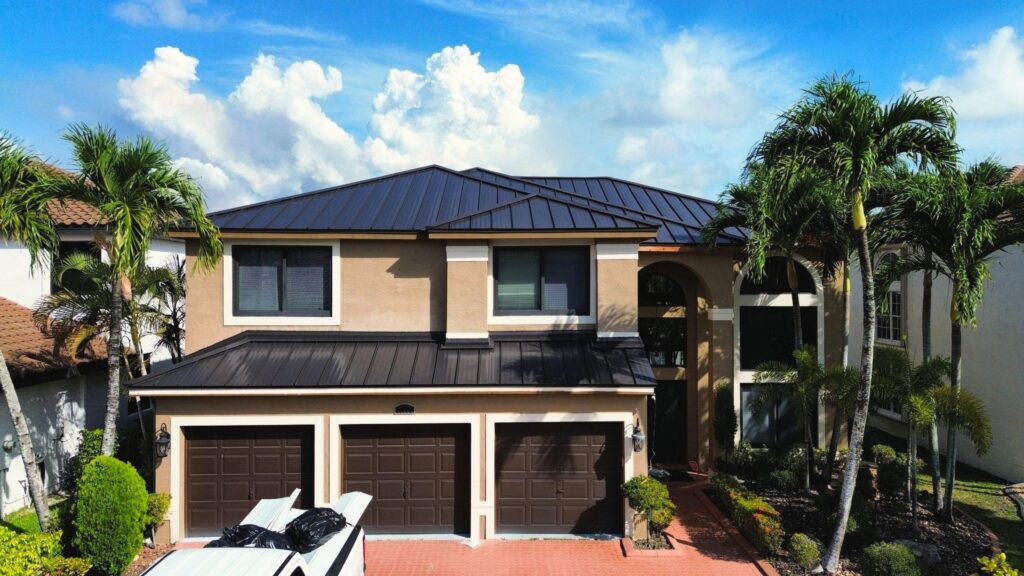Roofing contractors installing standing seam metal panels on commercial building
